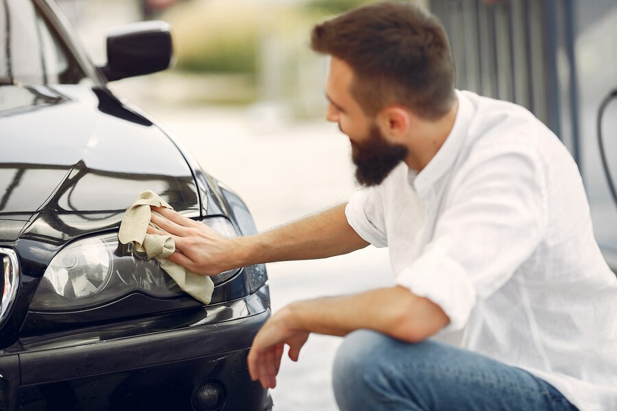 man-white-shirt-wipes-car-car-wash_1157-27235 Service worker painting car for sleek finish